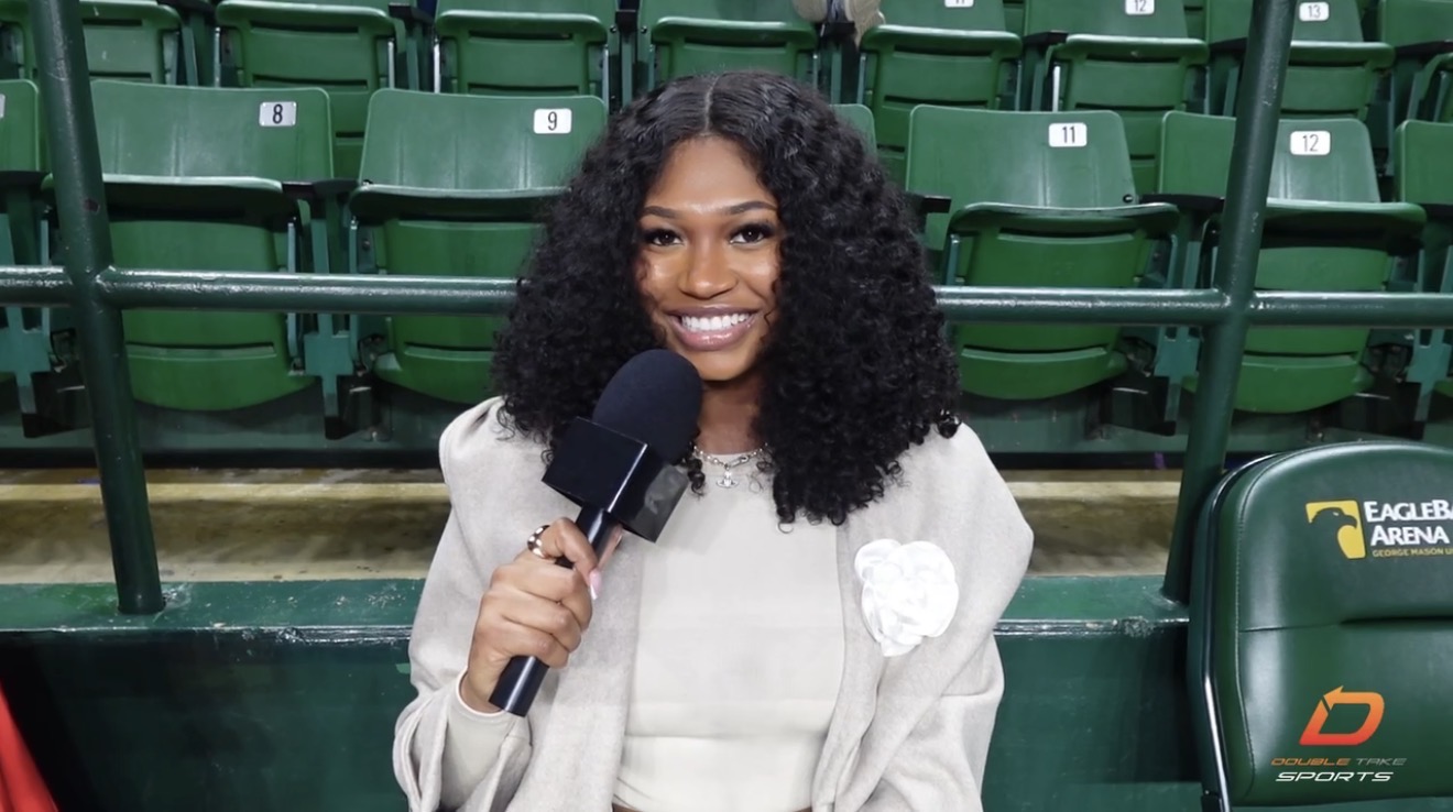 Jalynn Holmes holding a microphone in the stands at EagleBank Arena